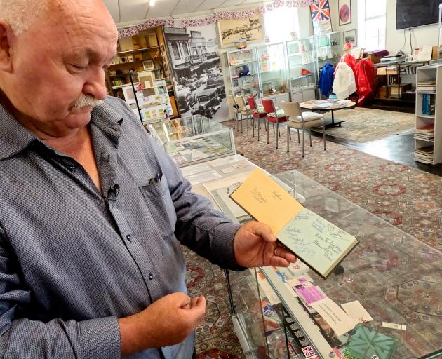 New Brighton Museum president Wayne Hawker with an autograph book featuring the signatures of...