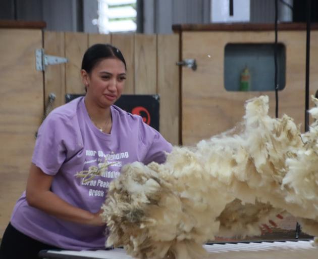 Mataura woolhandler Lucy Elers throws a fleece during the junior woolhandling final, which she...