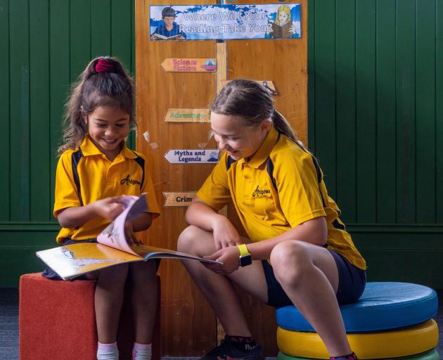 Willow Logavatu (left), 5, and Aaliyah Nehoff, 11, read a book together in the reopened Ardgowan...