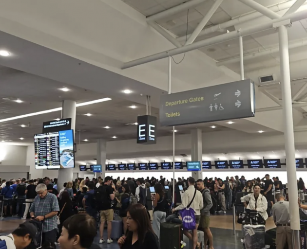 People queue at Auckland Airport after a Monday night flight to Chile was cancelled. Photo: RNZ