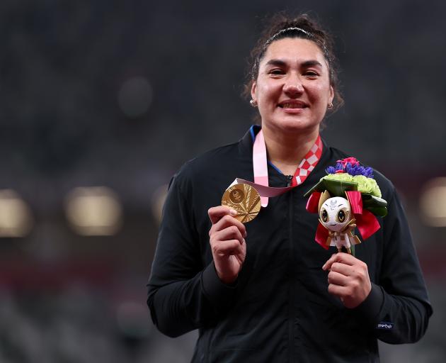 New Zealander Lisa Adams stands on the dais after winning the gold medal in the women’s shot put...