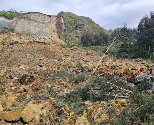 People work to free those trapped in the massive landslide in Enga province, Papua New Guinea....