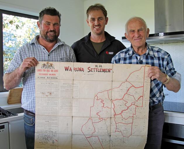 Terry McHaffie (left), his cousin Leigh and uncle Peter hold the original cloth map of Wairuna...