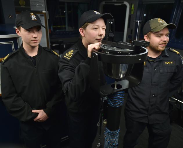 On the bridge of HMNZS Taupō in Otago Harbour last night are (from left) naval cadets Mitchell...