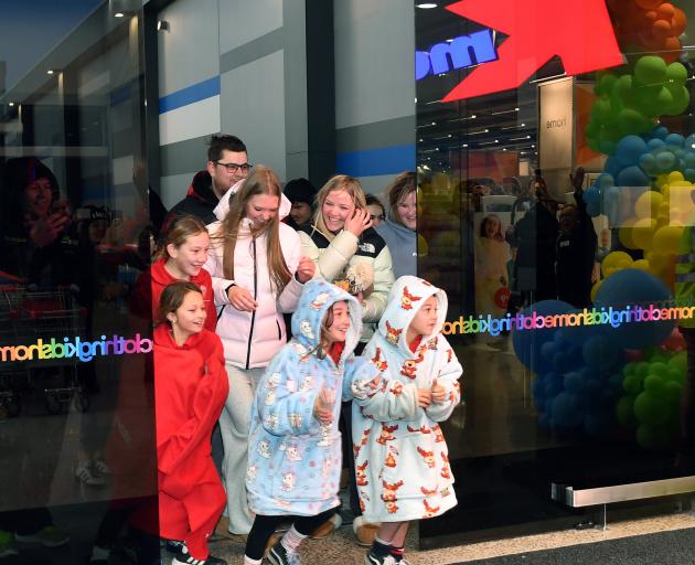 Shoppers race in to make a purchase as the doors officially open at Kmart Dunedin.