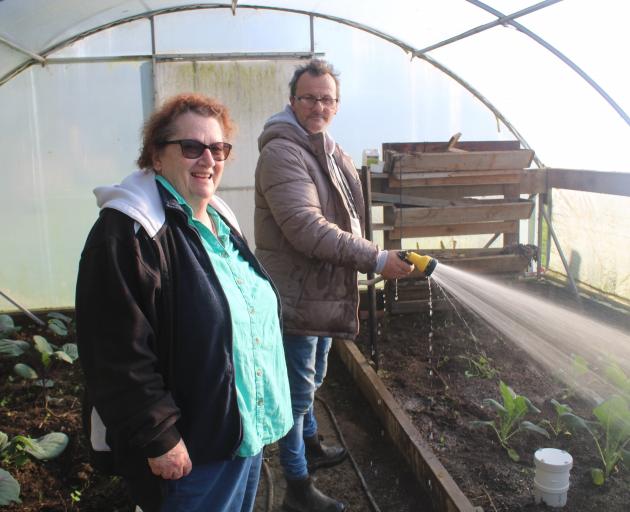 Karen Clearwater oversees Rodney Flowers watering the plants at Bainfield Gardens.