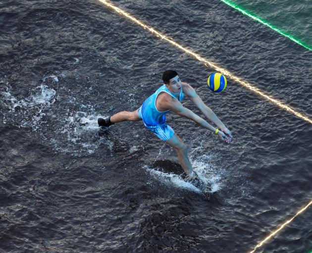 A man plays volleyball during an international "volleyball on water" tournament where teams...
