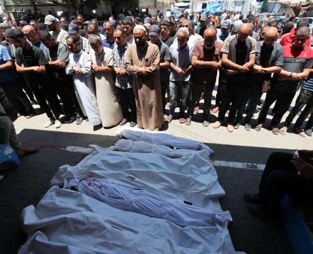 Palestinians mourn loved ones killed in Israeli strikes, in Deir Al-Balah in the central Gaza...