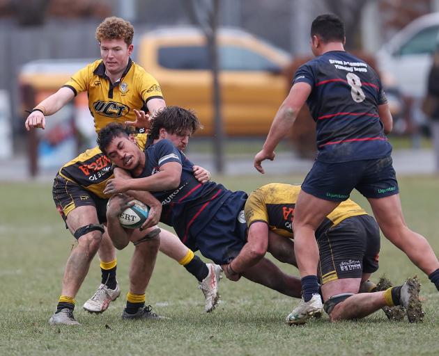 Arrowtown loosie Alesana Tulafono is wrapped up by two Upper Clutha players at Jack Reid Park...