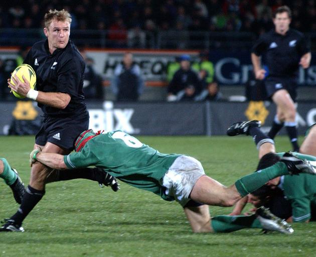 Robertson is tackled by Irishman Anthony Foley during a test at Carisbrook in 2002. PHOTO: ODT FILES