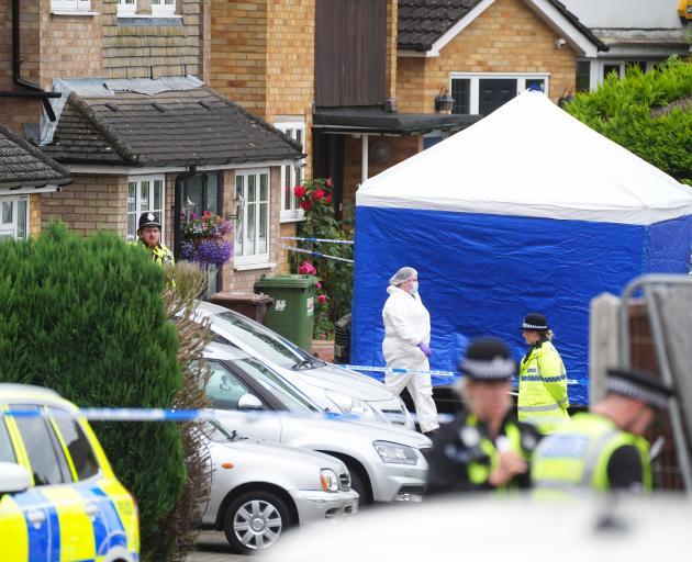 A police forensics tent outside a property in the town of Bushey where three people were killed....