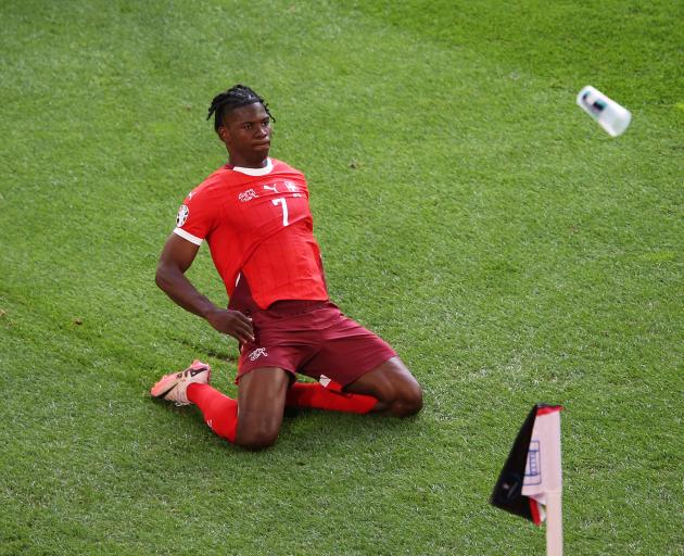 Breel Embolo celebrates scoring Switzerland's first goal as a fan throws a plastic cup during...