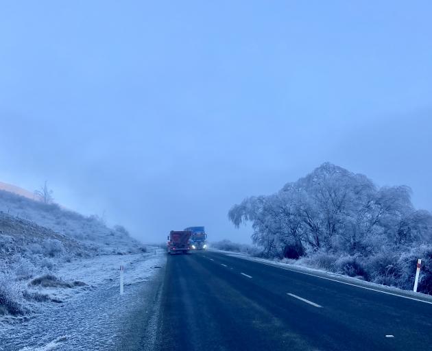 Trucks drive through a hoar frost beside Lake Benmore near Omarama. Photo: Stephen Jaquiery