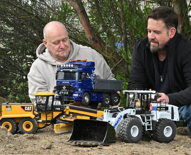 Murray Wright (left) and Glenn Lawrence show off their remote-controlled earthmoving models at...