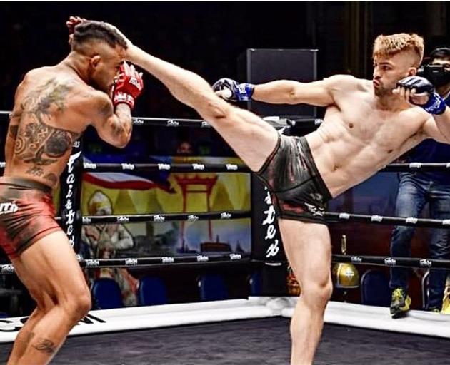 Jack Ferguson kicks out in a competitive mixed martial arts fight in Thailand.