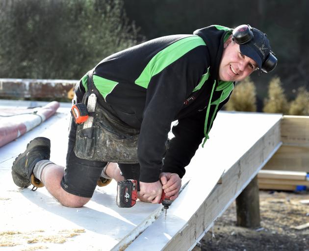 Dunedin builder Sacha Gray drills a hole on a building site. The cost to build a new house in New...