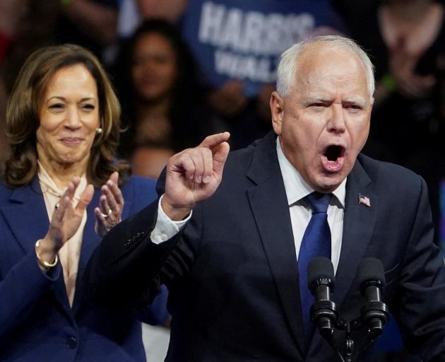 Kamala Harris applauds her new running mate Tim Walz during a campaign event in Philadelphia....