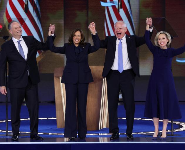 Vice President Kamala Harris stands with husband Doug Emhoff (left), Democratic vice presidential...