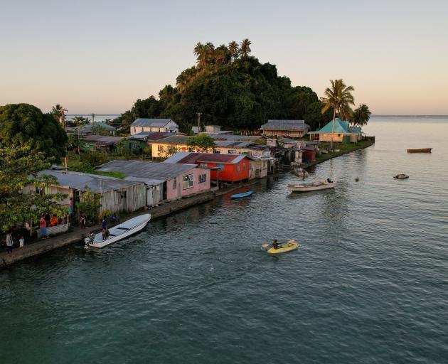 The morning's first rays of sunlight hit the island community of Serua Village, Fiji, in this...