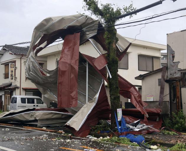 An object blown by strong winds caused by Typhoon Shanshan lies stranded on a power line in...