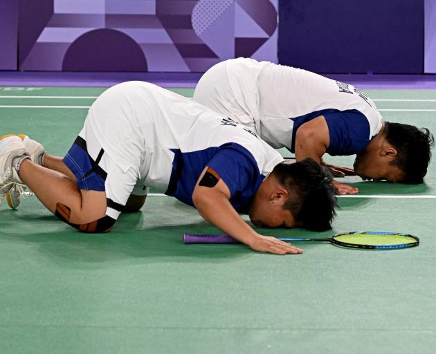 Indonesian badminton players Rina Marlina and Subhan Subhan celebrate after winning their match...