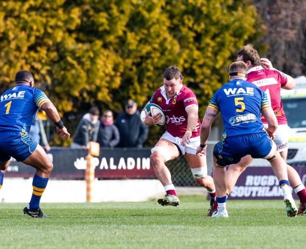 Southland No 8, Dylan Nel, on the charge against Otago defenders George Bower (left) and Fabian...