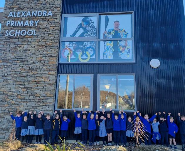 Alexandra Primary School pupils celebrate Finn Butcher's win in front of a window display of him...