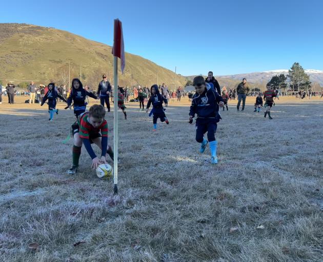 Matakanui player Finn Chisholm, 6, scores just in front of Glenorchy’s Monty Sharpe, 7, at the...