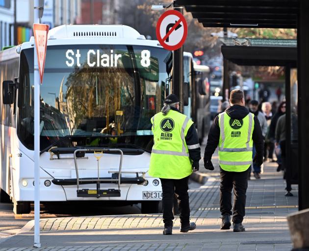 Security guards patrol the bus hub in Great King St on Friday afternoon. PHOTO: GERARD O’BRIEN