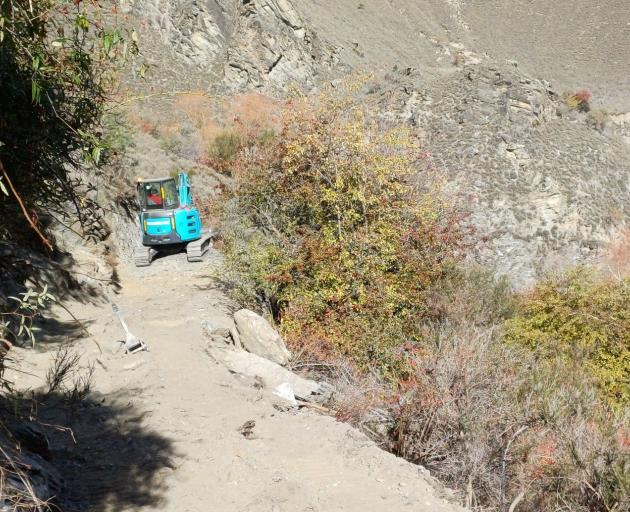 A digger navigates tight conditions on the Kawarau Gorge Trail, opposite the Nevis confluence....