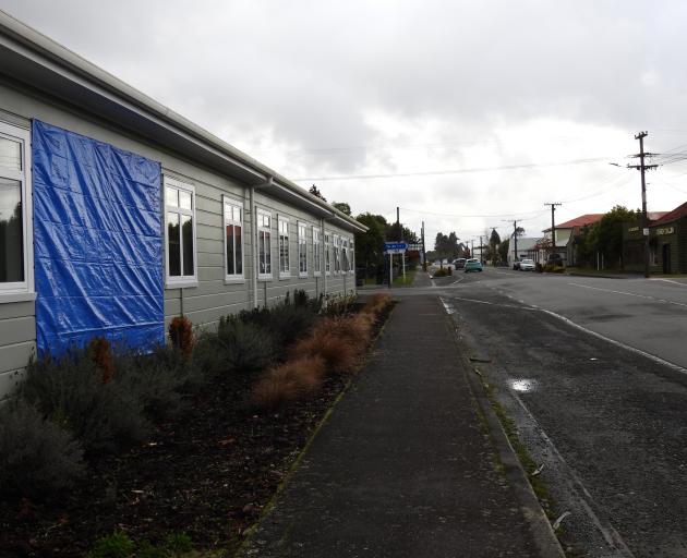 A second tarpaulin hides the sign along the side of the building facing the State Highway in Kumara.