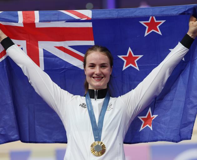 Ellesse Andrews holds the New Zealand flag aloft after being presented her gold medal for the...