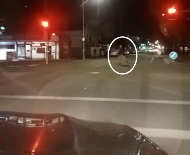 A woman runs for her life as the driver runs a red light and bears down on her.