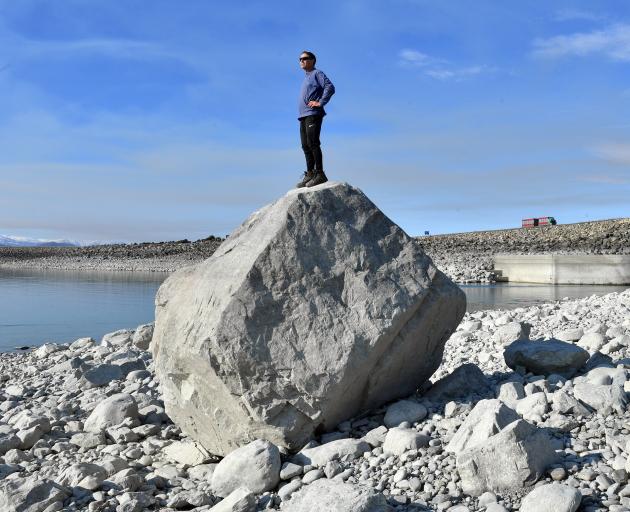 Grant Pearson studies Lake Pukaki from a rock near the outlet which is covered with water when...