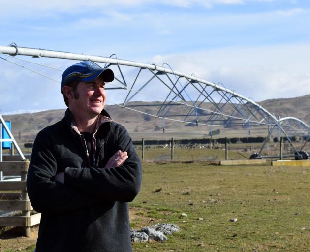 Farmer Cam Nicolson stands on a "fairway" on his farm in Poolburn which features a pivot...