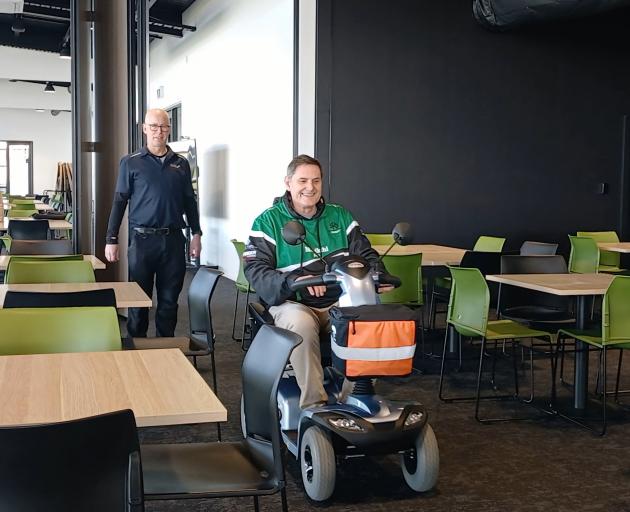 Marty Godwin (left) and Tim Hyde-Smith take a mobility scooter for a ride through the Fraser Park...