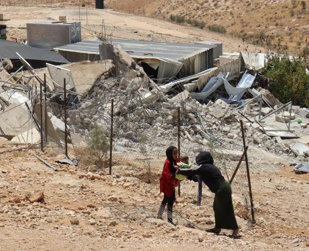 Palestinian girls in front of a house destroyed by Israeli soldiers. 