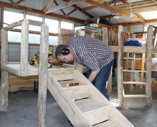 Trust Stedfast works on furniture in his workshop. Photo: Supplied