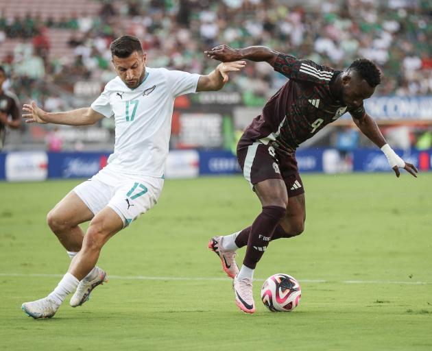 Kosta Barbarouses of New Zealand and Julian Quinones of Mexico vie for the ball in the first half...