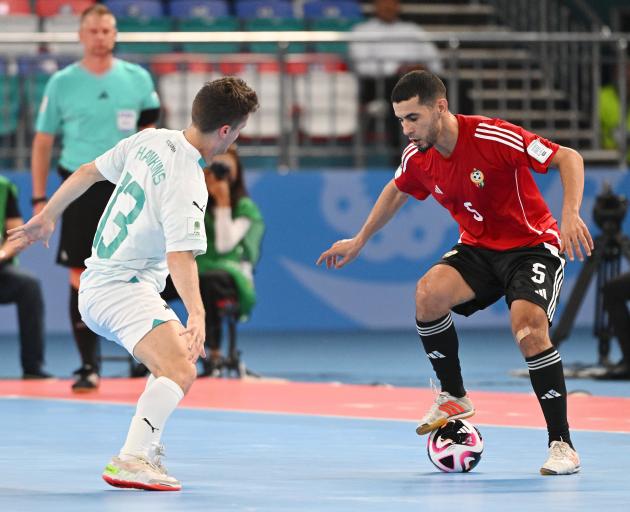 Futsal Whites player Oban Hawkins, of Dunedin, tries to shut down Libyan attacker Siliman...