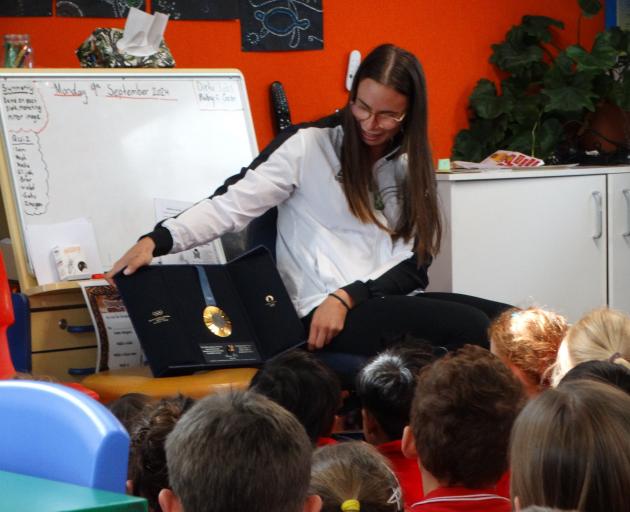 Kayaker Olivia Brett shows off her Olympic gold medal to the pupils at Five Forks School...