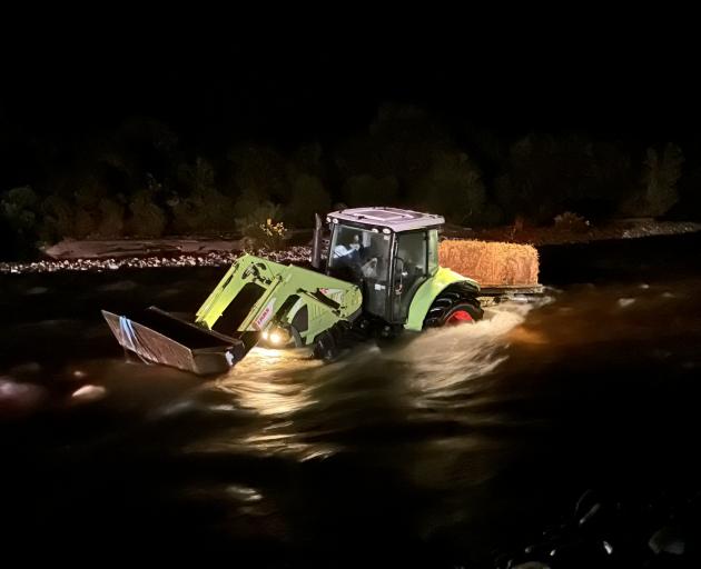 A tractor, with six occupants, was stuck in the middle of a surging river on the West Coast at...