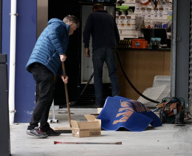 Staff clean up at Gun City after the ram-raid. Photo: George Heard