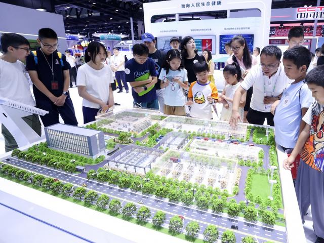 Visitors view a smart park model of State Grid Tianjin Electric Power at the 26th China Beijing...