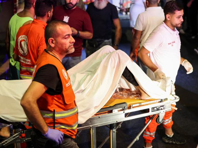 A person is carried outside American University of Beirut Medical Center after Hezbollah fighters...