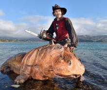 Waitati-based chainsaw carver Adrian ‘‘A.d’’ Pugh poses with one of his creations Henrietta the...