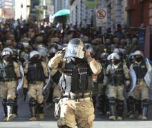 Military police make their way into the central square in Bolivia's capital La Paz as an...