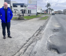 Simeon Brown and Christopher Luxon survey potholes at an earlier announcement. Photo: RNZ