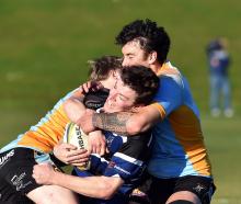Kaikorai centre Troy Anstiss is swamped by University defenders Stanley McClure (left) and Thomas...