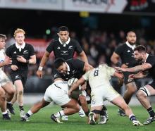 Asafo Aumua of the All Blacks is tackled during tonight's test match between New Zealand and...